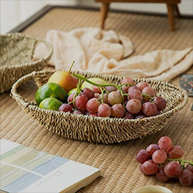 Handwoven seagrass fruit basket for displaying and storing fresh fruit.